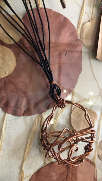 QUARTIERI Tribal: pendente tondo intrecciato su se stesso con filo di rame e cuoio nero.